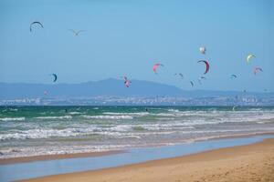 Kiteboarding kitesurfing kiteboarder kitesurfer kites on the ocean beach photo