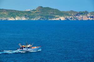 Greek fishing boat in Aegean sea near Milos island, Greece photo