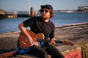 Street musician playing electric guitar in the street photo