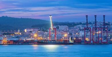 View of Lisbon port with ship and port cranes in the evening photo