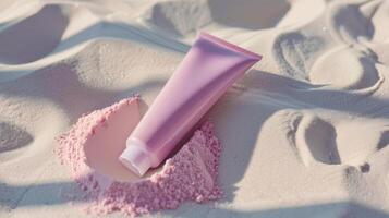 A pink skincare tube lying in white sand. photo