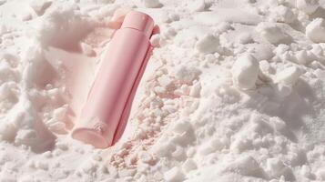 A pink skincare tube lying in white sand. photo