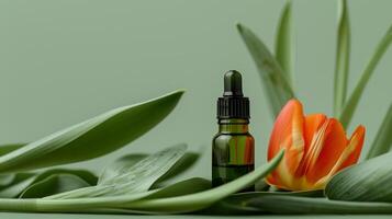 A bottle of green oil is placed on the long leaves, with an orange tulip next to it. photo