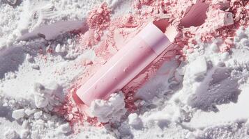 A pink skincare tube lying in white sand. photo