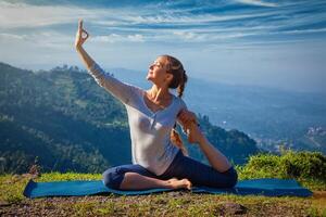 Sorty fit woman doing yoga asana outdoors in mountains photo