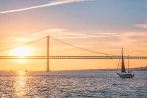 View of 25 de Abril Bridge over Tagus river on sunset. Lisbon, Portugal photo