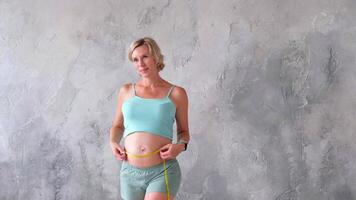 A pregnant woman measuring her stomach with measuring tape video