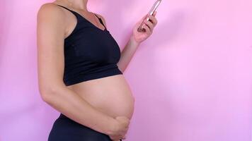Nahansicht Abdomen von ein schwanger Frau. das Mädchen Schlaganfälle das schwanger Magen. video