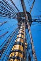 Masts of old wooden sailing ship with ropes and shroud photo