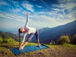 Woman doing Ashtanga Vinyasa yoga asana Utthita trikonasana photo