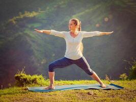 mujer haciendo yoga asana virabhadrasana 2 - guerrero actitud al aire libre foto