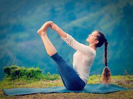 Woman doing Ashtanga Vinyasa Yoga asana outdoors photo