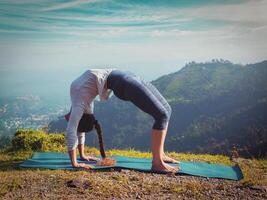 mujer haciendo Ashtanga vinyasa yoga asana urdhva dhanurasana foto