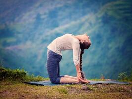 mujer haciendo yoga asana ustrasana camello actitud al aire libre foto