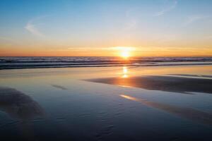 Atlantic ocean sunset with surging waves at Fonte da Telha beach, Portugal photo