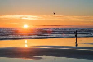 atlántico Oceano puesta de sol con surgiendo olas a fonte da telha playa, Portugal foto