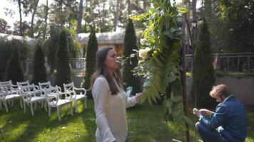 Staff event agency at work. Florists mount, decorate flowers arch for wedding ceremony. Work creating wed decor by professional. Floristics. Decorator working with flowers composition for wedding arch video