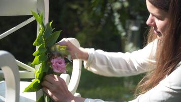 mujer decorador decora blanco sillas para un al aire libre Boda ceremonia en patio interior. Boda agencia empleado decora calle mueble para Boda fiesta afuera. bodas mueble embellecimiento. video