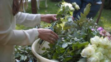 floristas montar, Decorar con flores arco para Boda ceremonia. decoradores trabajando a evento, cumpleaños, aniversario, fiesta. evento decoración con Fresco flores rústico estilo. diseñador a trabajar. video