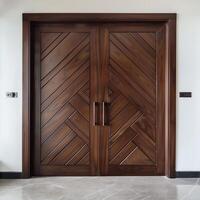 Dark brown wooden door with diagonal grooves on the surface with white wall in background. photo