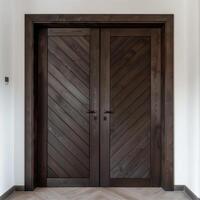 Dark brown wooden door with diagonal grooves on the surface with white wall in background. photo