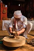 Indian potter at work, Shilpagram, Udaipur, Rajasthan, India photo