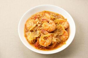 Udang Asam manís, dulce y agrio camarón con tomate y chile salsa. indonesio alimento. foto