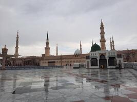 Madinah, Saudi Arabia, 29 March 2024 - Beautiful daytime outdoor view of Prophet's Mosque Madinah in dark clouds and rain. photo