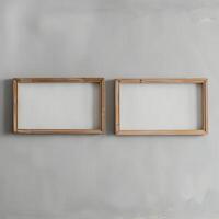 Two empty, wide, wooden frames on a light gray plain wall. photo