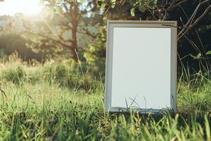 A plain white frame mockup, laying on grass in sunny day. photo