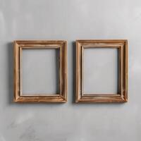 Two empty, wide, wooden frames on a light gray plain wall. photo