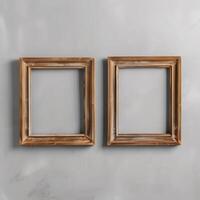 Two empty, wide, wooden frames on a light gray plain wall. photo