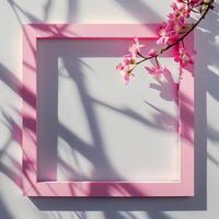 A pink square frame with a shadow with flowers in background. photo