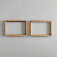 Two empty, wide, wooden frames on a light gray plain wall. photo