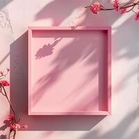 A pink square frame with a shadow with flowers in background. photo