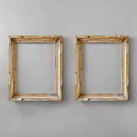 Two empty, wide, wooden frames on a light gray plain wall. photo