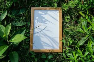 A plain white frame mockup, laying on grass in sunny day. photo