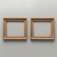 Two empty, wide, wooden frames on a light gray plain wall. photo