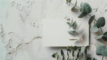 A lat lay card mockup adorned with eucalyptus branche and flowers. photo