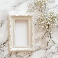 A white picture frame with an empty space inside, sitting on top of a marble surface. photo