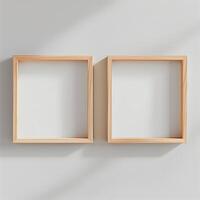 Two empty, wide, wooden frames on a light gray plain wall. photo