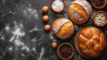 Freshly baked breads surrounded by food and spices on dark background. photo