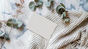 A lat lay card mockup adorned with eucalyptus branche and flowers. photo