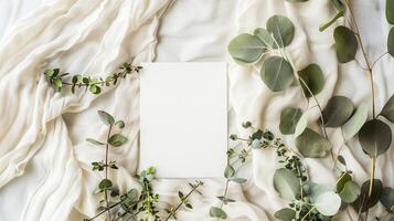 A lat lay card mockup adorned with eucalyptus branche and flowers. photo