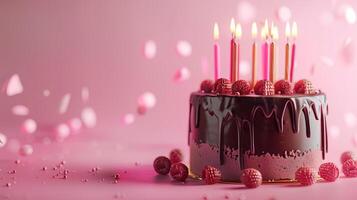 A Birthday chocolate layer cake with candles and pink background. photo