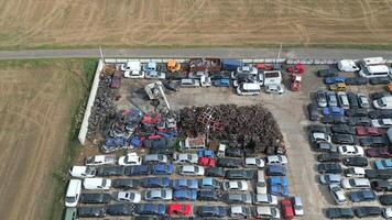 Aerial view of crane crashing scrap metal cars in a junkyard. video
