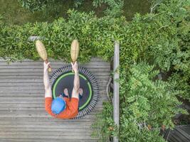 exercising with Indian clubs on a mini trampoline photo