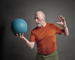 mayor hombre hacer ejercicio con un pesado golpe o medicina pelota foto