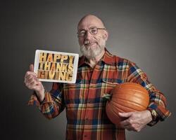 Happy Thanksgiving - a senior man with pumpkin photo