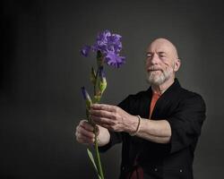 senior man in kimono admiring an iris flower photo